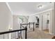 Second floor hallway with carpet, white trim, a pendant light, and view of the front yard through an arched window at 2015 Towne Lake W Hls, Woodstock, GA 30189