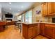 Open kitchen with wooden cabinets and granite countertops overlooking living area at 2015 Towne Lake W Hls, Woodstock, GA 30189
