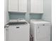 Clean laundry room with Maytag washer and dryer and overhead cabinets at 2015 Towne Lake W Hls, Woodstock, GA 30189