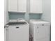 Efficient laundry room with white cabinets, a washing machine, and a dryer at 2015 Towne Lake W Hls, Woodstock, GA 30189