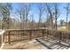 A wooden deck with a railing overlooks a backyard with bare trees and bushes at 3313 Alhambra Cir, Hampton, GA 30228
