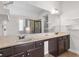 Bathroom featuring a double sink vanity with dark wood cabinets, a large mirror and a glass door shower at 3313 Alhambra Cir, Hampton, GA 30228