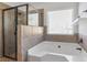 Bathroom featuring tiled shower with glass door, a soaking tub and a window at 3313 Alhambra Cir, Hampton, GA 30228