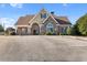 Clubhouse featuring brick and siding, an arched entryway, a well maintained landscape, and parking spots at 3313 Alhambra Cir, Hampton, GA 30228