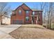Charming two-story brick home features a two-car garage and a well-manicured lawn at 3313 Alhambra Cir, Hampton, GA 30228