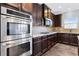 Close-up of stainless steel oven and microwave with wood cabinets and granite countertops at 3313 Alhambra Cir, Hampton, GA 30228