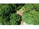 Aerial view of home surrounded by lush green trees with deck, picnic table, and in-ground trampoline at 1638 River Trce, Auburn, GA 30011