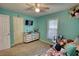 Bedroom featuring a daybed, ceiling fan, bright blue walls, window, and a dresser for storage at 1638 River Trce, Auburn, GA 30011