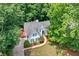 Aerial view of home nestled among mature trees with large front yard at 2605 Woodland Hills Dr, Cumming, GA 30040