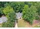 Aerial view of home nestled among mature trees with large front yard and driveway at 2605 Woodland Hills Dr, Cumming, GA 30040