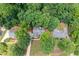 Aerial view of neighborhood, homes nestled among mature trees with large front yards and driveways at 2605 Woodland Hills Dr, Cumming, GA 30040