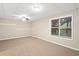 Basement features neutral walls, ceiling fan, carpet, and window view of the outdoors at 2605 Woodland Hills Dr, Cumming, GA 30040