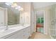 Bathroom featuring double vanity, large mirror, and a spacious shower with glass door at 2605 Woodland Hills Dr, Cumming, GA 30040