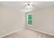 Cozy bedroom featuring neutral carpet, a window with wooded view, and a ceiling fan at 2605 Woodland Hills Dr, Cumming, GA 30040
