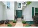 Front entryway with a green door, black railings, and manicured landscaping at 2605 Woodland Hills Dr, Cumming, GA 30040
