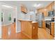 Kitchen features stainless appliances and convenient breakfast bar with hardwood floors at 2605 Woodland Hills Dr, Cumming, GA 30040