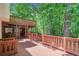 Wooden porch area with railing and staircase, surrounded by lush greenery and trees at 2605 Woodland Hills Dr, Cumming, GA 30040