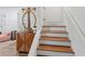 Bright foyer with wooden floors on stairs complemented by a decorative mirror and cabinet at 3147 Buford Ne Hwy # 8, Brookhaven, GA 30329