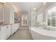Bright bathroom with white cabinetry, soaking tub, and glass enclosed shower at 4298 Kingston Gate Cv, Chamblee, GA 30341