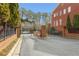 Gated community entrance with brick pillars, iron fence, and mature landscaping at 4298 Kingston Gate Cv, Chamblee, GA 30341