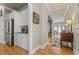 Hallway with hardwood floors that connects to kitchen with stainless steel fridge and dining area with ample natural light at 4298 Kingston Gate Cv, Chamblee, GA 30341
