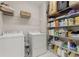 Functional laundry room with washer, dryer, storage shelves, and utility sink at 4298 Kingston Gate Cv, Chamblee, GA 30341
