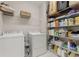Efficient laundry room with storage shelves and modern washer and dryer at 4298 Kingston Gate Cv, Chamblee, GA 30341