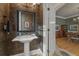 Charming powder room adjacent to dining area with pedestal sink, ornate wallpaper and stylish mirror at 4298 Kingston Gate Cv, Chamblee, GA 30341