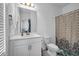 Bright bathroom featuring a single sink vanity, toilet, and bathtub with a patterned shower curtain at 4565 Sims Park Ovlk, Suwanee, GA 30024