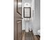 Well-lit half-bathroom with pedestal sink, decorative mirror, and modern fixtures at 4565 Sims Park Ovlk, Suwanee, GA 30024
