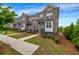 Charming brick townhome featuring a well-maintained lawn, landscaped shrubs, and inviting walkway at 4565 Sims Park Ovlk, Suwanee, GA 30024
