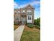 Brick townhome featuring a walkway, manicured lawn, and landscaped shrubbery leading to the entrance at 4565 Sims Park Ovlk, Suwanee, GA 30024