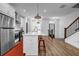 Bright kitchen with stainless appliances, white cabinetry, a large island, and hardwood floors at 4565 Sims Park Ovlk, Suwanee, GA 30024