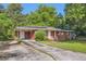 Traditional brick ranch with covered entry, showcasing a convenient carport and landscaped front yard at 7577 Haley Dr, Jonesboro, GA 30236