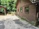 Exterior of a rustic cabin with a long driveway surrounded by trees at 418 Honey Suckle Ln, Stockbridge, GA 30281