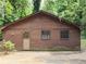 Charming exterior view showcasing natural wood siding with lush landscaping at 418 Honey Suckle Ln, Stockbridge, GA 30281