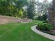 Expansive backyard featuring a retaining wall, lush green lawn, and mature trees at 45 Mountain Crest Dr, Oxford, GA 30054