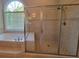 Well-appointed bathroom with a shower and luxurious soaking tub offers space to relax and unwind with natural light at 45 Mountain Crest Dr, Oxford, GA 30054
