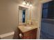 Well-lit bathroom vanity with granite countertop and view into hallway with staircase at 45 Mountain Crest Dr, Oxford, GA 30054