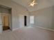 Large bedroom with a ceiling fan, neutral carpeting, and access to closets and additional rooms at 45 Mountain Crest Dr, Oxford, GA 30054