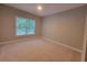Neutral bedroom featuring a window bringing in natural light, carpeted floors, and a ceiling fan at 45 Mountain Crest Dr, Oxford, GA 30054
