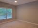 Neutral-toned bedroom featuring a ceiling fan and a window with views of the private backyard at 45 Mountain Crest Dr, Oxford, GA 30054