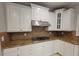 Granite countertop and stainless vent over gas range in updated kitchen at 45 Mountain Crest Dr, Oxford, GA 30054