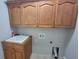Laundry room with utility sink and ample wood cabinet storage at 45 Mountain Crest Dr, Oxford, GA 30054
