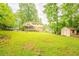 Large, grassy backyard featuring a storage shed and a screened-in porch on the back of the house at 5293 Sandy Shoals Ln, Stone Mountain, GA 30087