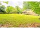 Expansive backyard featuring a screened-in porch on the home and mature shade trees around the perimeter at 5293 Sandy Shoals Ln, Stone Mountain, GA 30087