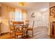 Bright dining area featuring a round table with ornate chairs, window with sheer curtains, and wood-look flooring at 5293 Sandy Shoals Ln, Stone Mountain, GA 30087