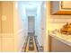 Hallway featuring neutral walls, white trim, an area rug, and access to the kitchen at 5293 Sandy Shoals Ln, Stone Mountain, GA 30087