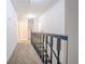 Hallway with carpet flooring, dark railing, and natural light, providing access to rooms on the second level at 5293 Sandy Shoals Ln, Stone Mountain, GA 30087