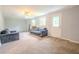 Large open living area with neutral carpet, windows, and rear access at 5293 Sandy Shoals Ln, Stone Mountain, GA 30087